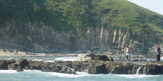 Tourists at the base of some of the Wild Coast's many cliffs
